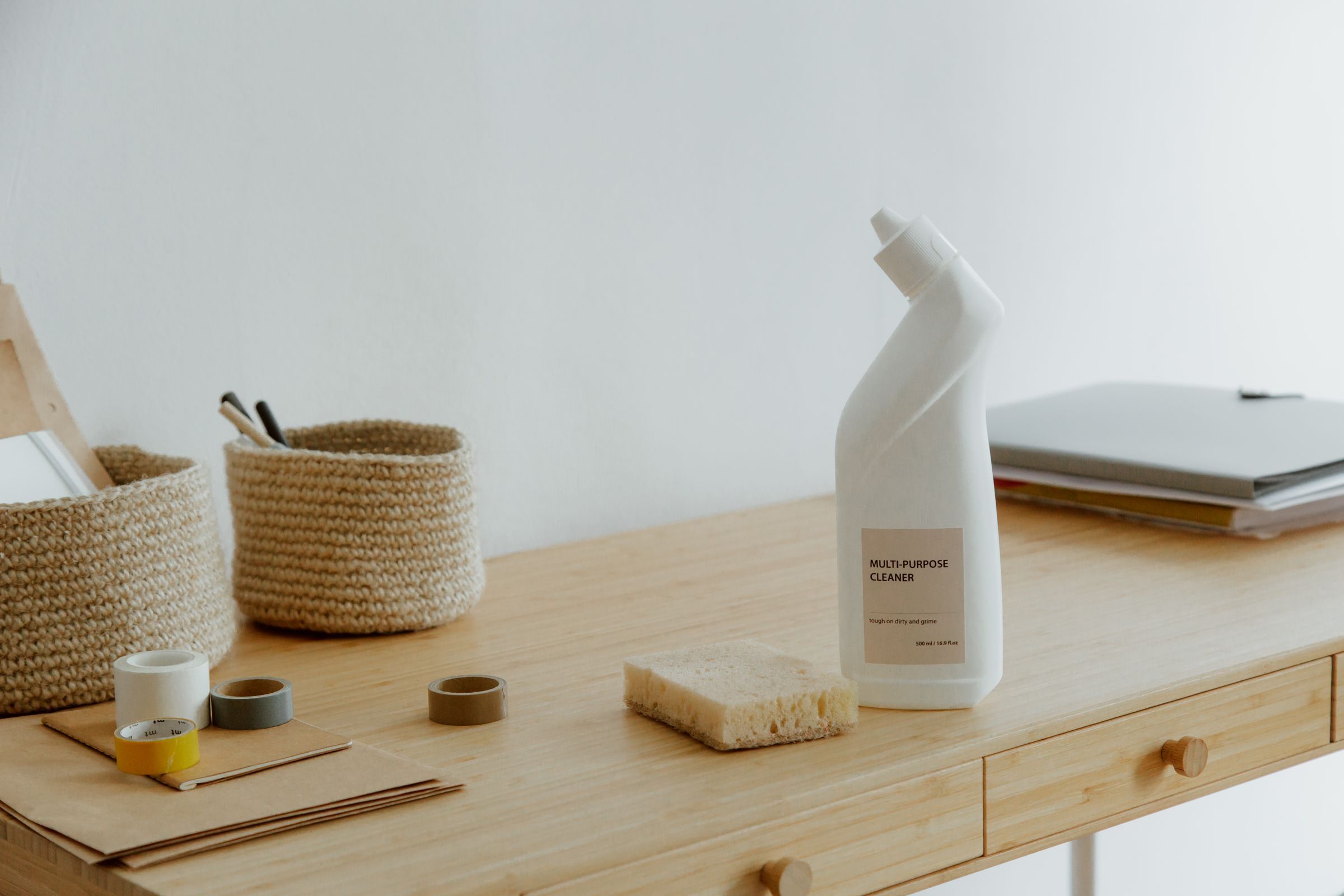 Cleaning products and a notepad on a tidy desk, ready to plan a cleaning